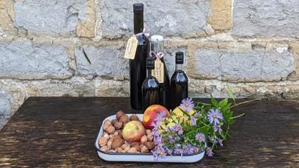 Blackberry liqueur, apples, nuts and seasonal flowers on a tray
